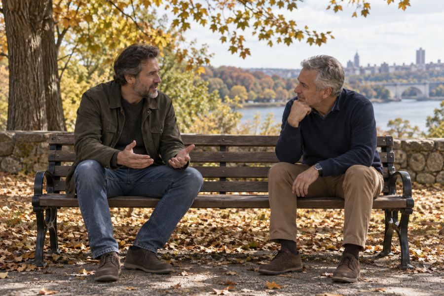 Two friends talking on a park bench.